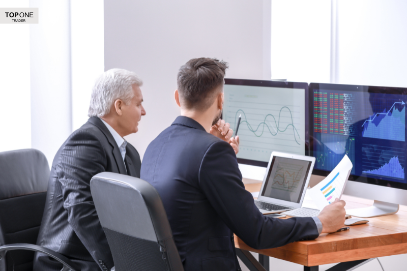Traders reviewing charts and graphs to identify bull flag pattern for prop firm strategy