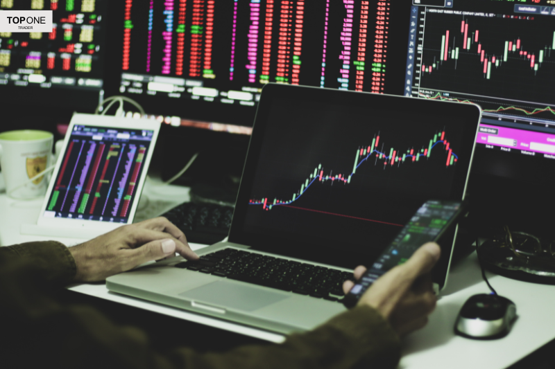 Trader analysing forex trading patterns on multiple screens for prop firm challenge success