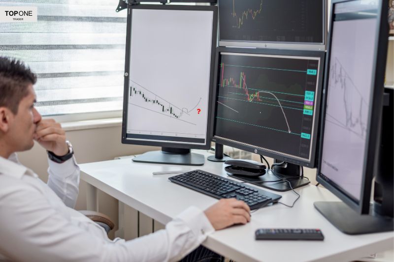 Trader analysing multiple screens to develop effective forex trading strategies